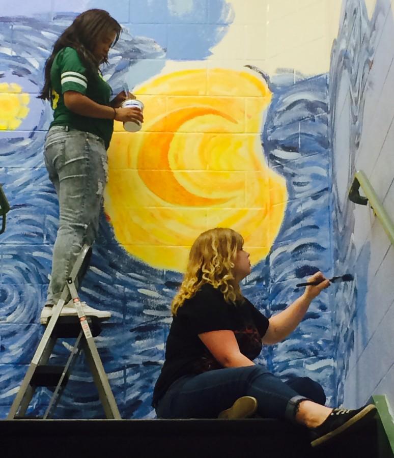 Seniors Taylar Epley right) and JaCamrie Collins brighten up a stairwell with their interpretation of Vincent van Goghs Starry Night.