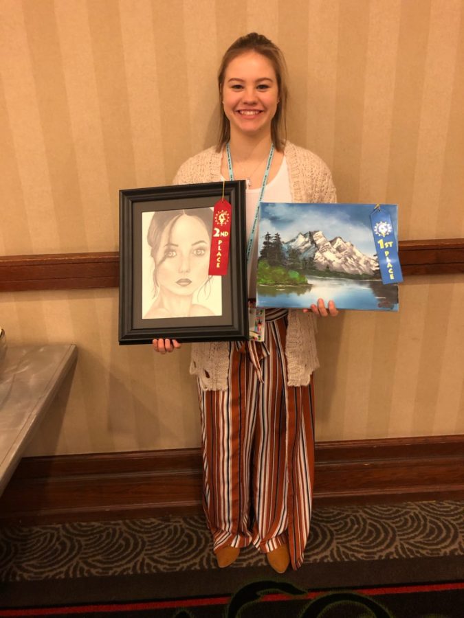 Caden Trevor with her second-place drawing and first-place painting.