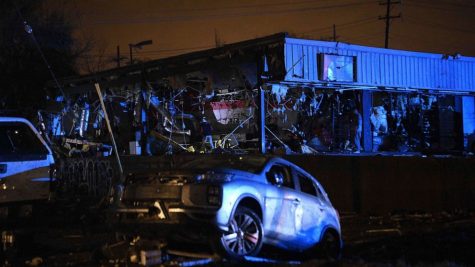 A buildings side ripped apart while a car has been destroyed